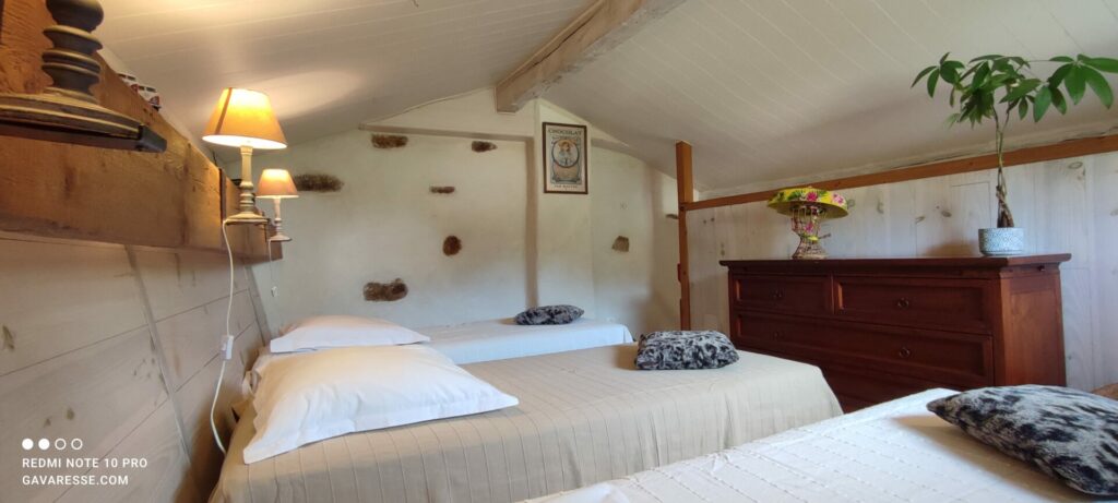 Chambre mansardée du Grand Gîte avec trois lits simples, mobilier en bois, décoration authentique, Le Pradet.
