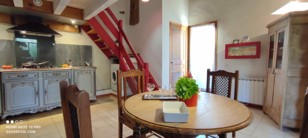 Séjour salle à manger et cuisine équipée du gîte L'Orangeraie avec escalier rouge, Mas de la Gavaresse, Le Pradet.