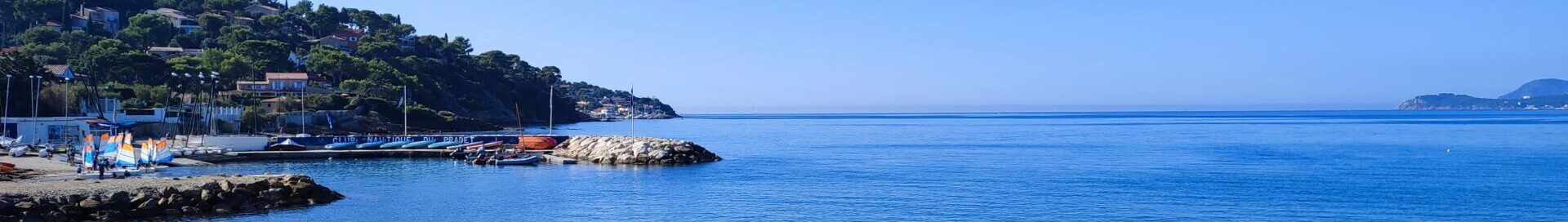 Vue panoramique sur le club nautique du Pradet, le port des Oursinières et la mer Méditerranée sous un ciel bleu.