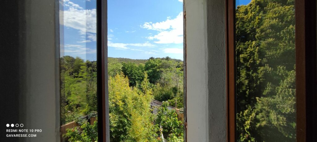 Vue depuis la fenêtre de la chambre parentale de L'Orangeraie sur le jardin et la colline, paysages provençaux, Le Pradet.