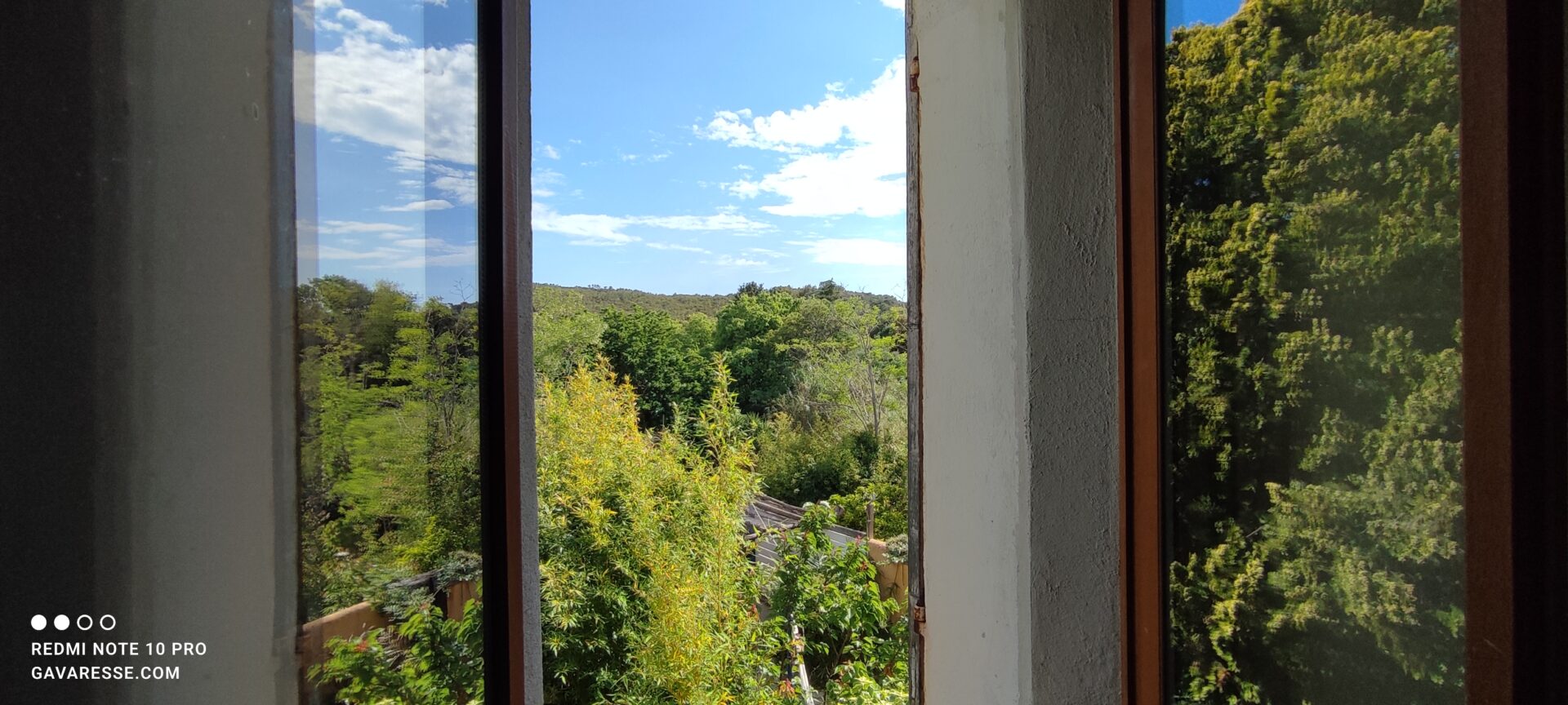 Vue depuis la fenêtre de la chambre parentale de L'Orangeraie sur le jardin et la colline, paysages provençaux, Le Pradet.