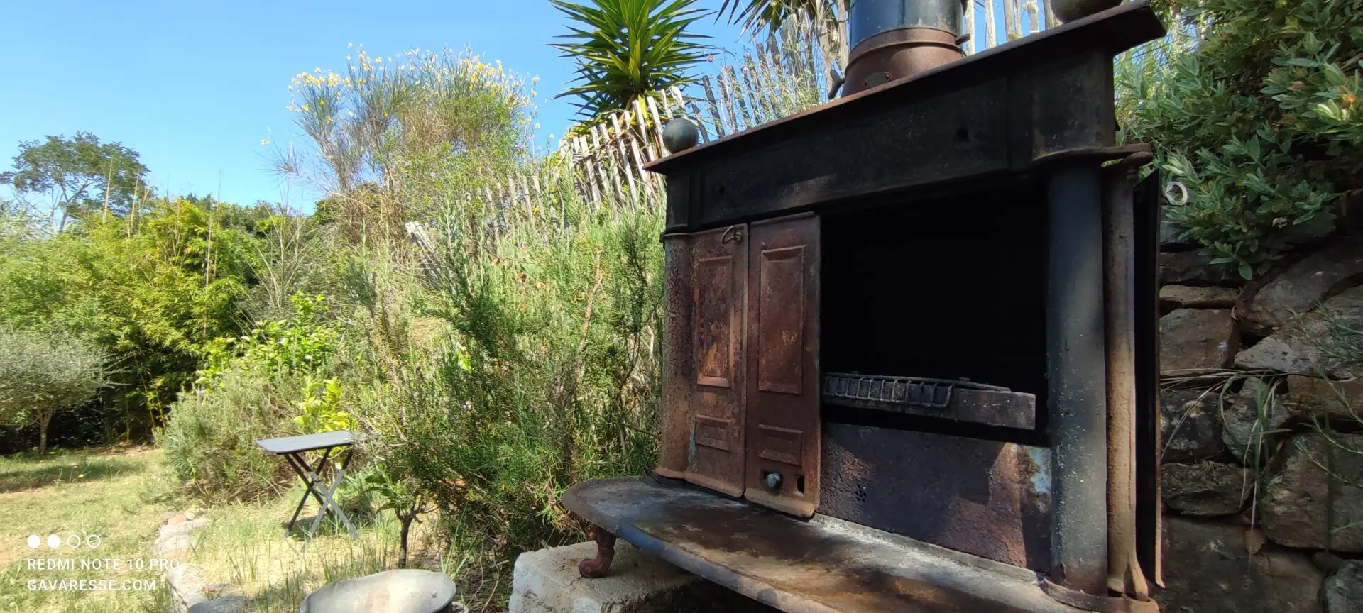 Gros plan sur le grill en fonte d'un barbecue original fait à partir d'un ancien poêle à bois, prêt à l'emploi pour les hôtes du Mas de la Gavaresse, esprit convivial et éco-responsable.